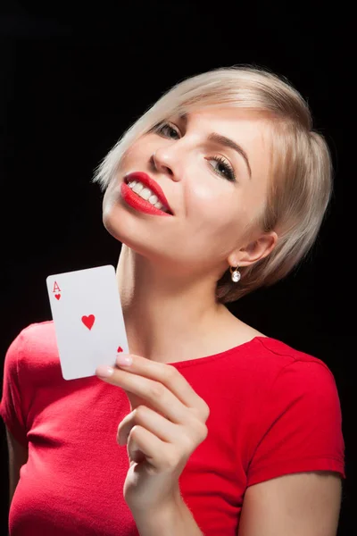 Schöne blonde Mädchen zeigt eine Pokerkarte — Stockfoto