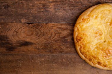 Tahta masada erimiş peynirli mini pizza. Metniniz için en üstteki görünüm.