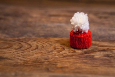 Mini, Noel Baba şapkasını ahşap arka planda ördü..