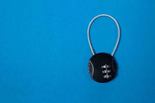 Small black iron cipher lock with a coded set on blue background — Stock Photo, Image