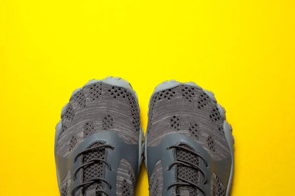 黄色背景的运动鞋灰色运动鞋 — 图库照片