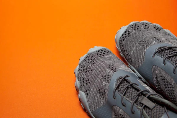 Sneakers grigie sportive isolate su sfondo arancione — Foto Stock