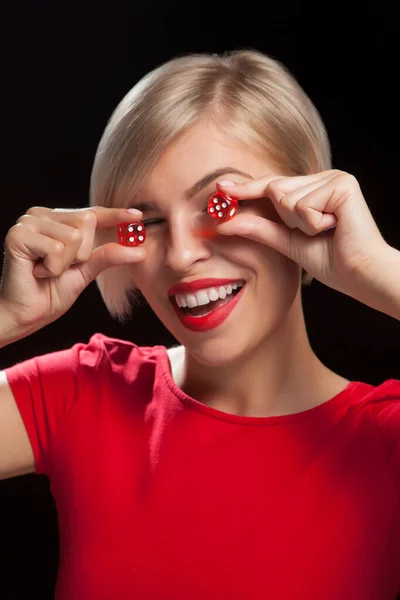 Mujer joven con dados rojos sobre fondo negro — Foto de Stock