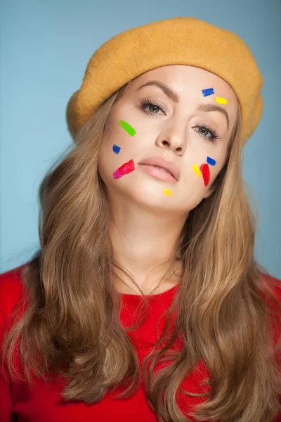 Retrato de uma mulher com pincelada de tinta colorida no rosto. — Fotografia de Stock