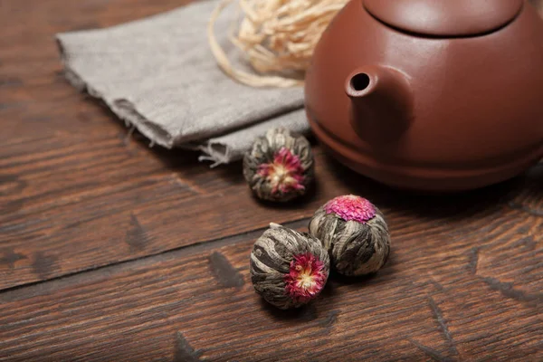 Глиняный китайский чайник с цветочным китайским чаем на старом деревянном столе — стоковое фото