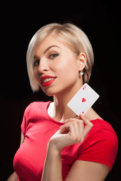 Mulher loira bonita mostrando um cartão de poker no fundo preto — Fotografia de Stock