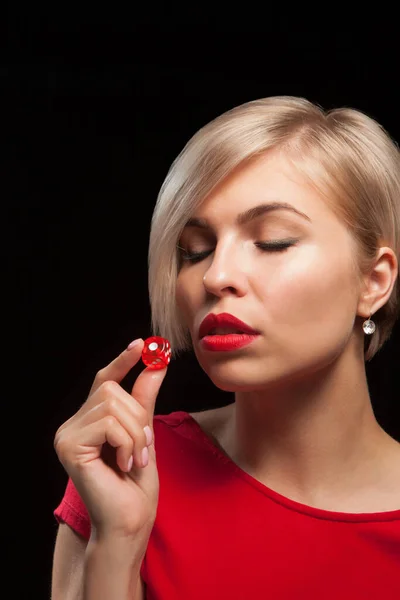 Young woman with red dice on black — Stock Photo, Image