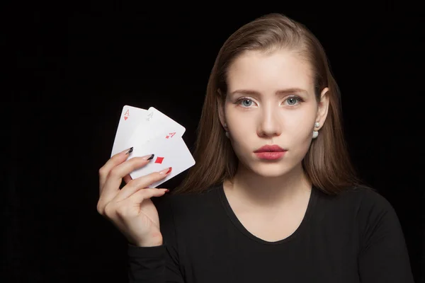 Schöne blonde Frau zeigt eine Pokerkarte auf schwarzem Hintergrund — Stockfoto
