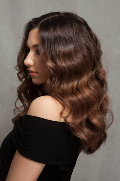 Красивая женщина с длинными кудрявыми волосами.