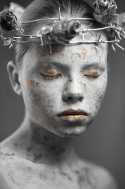 Mermer tenli, dikenli tel ve kuru güllerden bir çelenk takan genç bir kadının portresi..