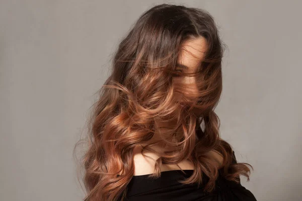 Beautiful woman with long brown curly hair. — Stock Photo, Image