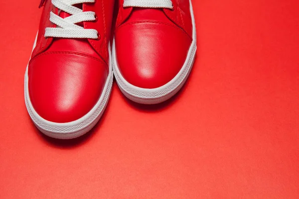Sport rode lederen sneakers op rode achtergrond — Stockfoto