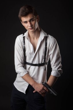 Siyah arka planda silahlı yakışıklı sıradan bir adam.