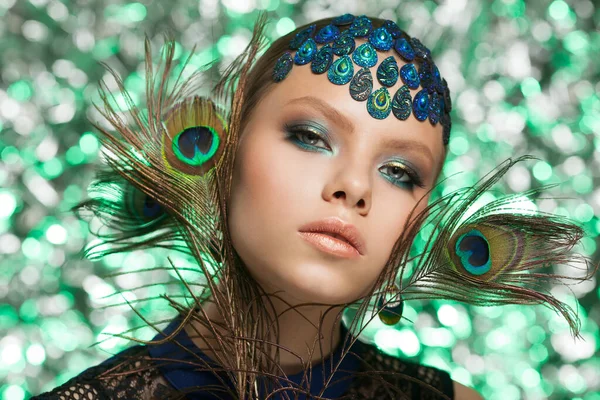 Hermosa cara de mujer de moda. Mujer en imagen de pavo real con plumas de pavo real. —  Fotos de Stock