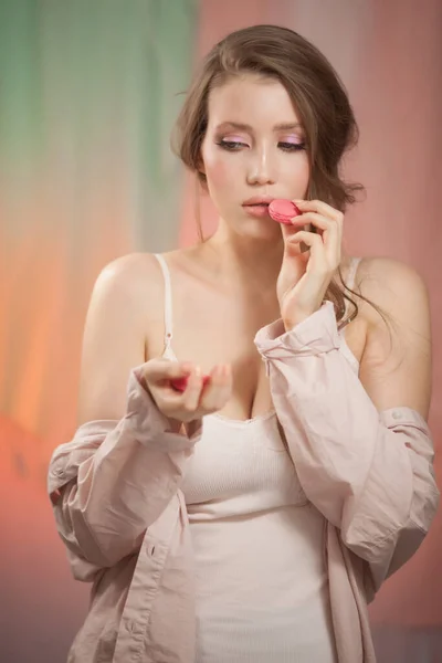 Mulher modelo de moda de beleza com maquiagem delicada e manicure tomando macaroons rosa — Fotografia de Stock