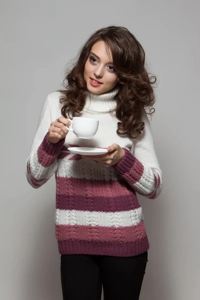 年轻的黑发女子 拿着一杯灰色背景的热茶 — 图库照片