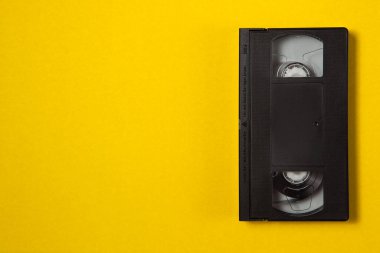 Sarı arka planda video kaset. Metin için en üstteki görünüm. Anılarını modern medyaya kaydet.