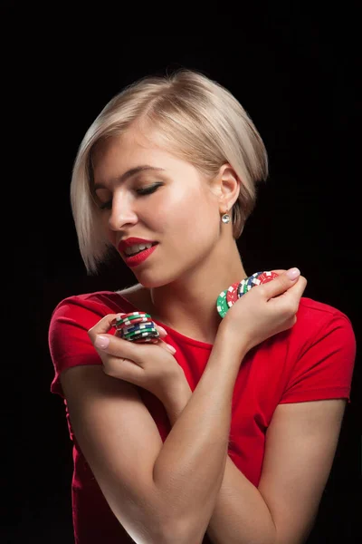 美しいブロンド女性ショーギャンブルチップ上の黒の背景 — ストック写真