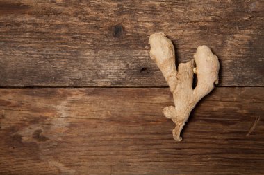 Eski ahşap masadaki taze zencefil kökü baharatını kapat.