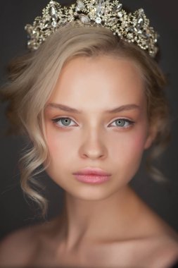 Saçında taç olan bir gelin görünümünde güzel bir sarışın kadın..