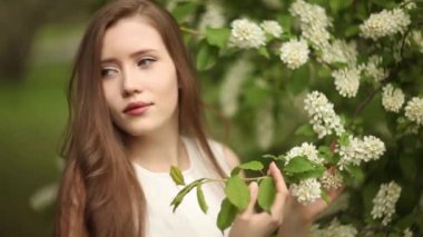 Bir kadın elinde çiçek açan kuş kirazından bir dal tutuyor. Bahar geldi. Çiçek açan doğa.