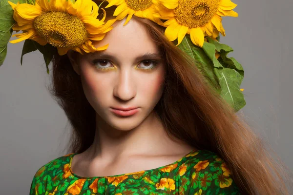 Mujer con maquillaje elegante y girasoles alrededor de su cabeza —  Fotos de Stock