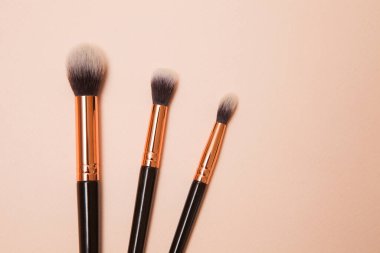 Pembe arka planda çeşitli kozmetik fırçalar. Profesyonel makyaj önleyici pudra göz farı fırçaları. Cilt bakımı için makyaj fırçaları ayarlandı.