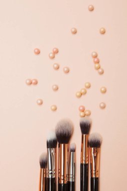 Pembe arka planda çeşitli kozmetik fırçalar. Profesyonel makyaj önleyici pudra göz farı fırçaları. Cilt bakımı için makyaj fırçaları ayarlandı.