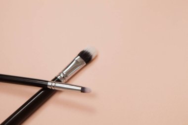 Pembe arka planda çeşitli kozmetik fırçalar. Profesyonel makyaj önleyici pudra göz farı fırçaları. Cilt bakımı için makyaj fırçaları ayarlandı.