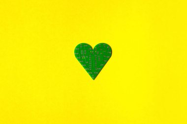 Sarı arka planda kalp şeklinde bir devre kartı. Sevgililer Günü konsepti fotoğrafı.