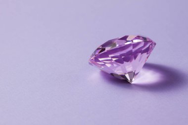 Mücevher tasarımı için mor değerli taş. Mor arka planda büyük elmas kristal.