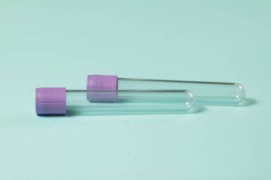 Mor boş vakum kan toplama tüpü testi EDTA ile birlikte turkuaz arka plan üzerinde tıbbi laboratuvar için antikoagülan.