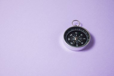 Mor arka planda pusula. Kavram işaretleri. Seyahat, turizm, bilim, kaybol, iş ve tasarım ve dekorasyon aracı.