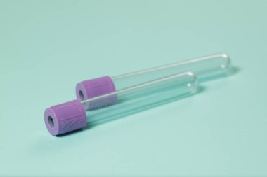 Mor boş vakum kan toplama tüpü testi EDTA ile birlikte turkuaz arka plan üzerinde tıbbi laboratuvar için antikoagülan.