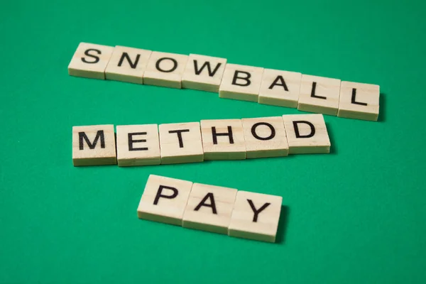 Snowball method pay off debt. Text snowball method pay made by wooden blocks. Financial concept.