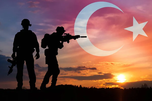 Turkish army concept. Silhouette of soldiers against a Turkish flag. Concept - protection, patriotism, honor.