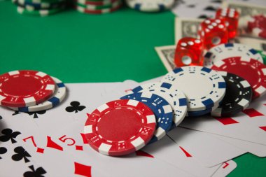 Klasik oyun kartları, çipler, kırmızı zarlar ve yeşil arka planda dolar. Kumar ve kumarhane konsepti.