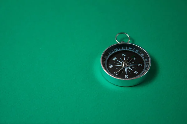 Kompass auf grünem Hintergrund. Konzept kennzeichnet Symbole. — Stockfoto