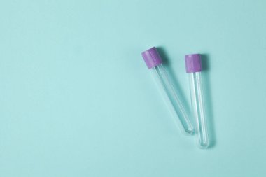 Mor boş vakum kan toplama tüpü testi EDTA ile birlikte turkuaz arka plan üzerinde tıbbi laboratuvar için antikoagülan.