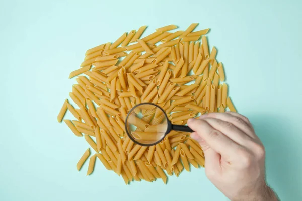 Mano Umana Che Tiene Una Lente Ingrandimento Sopra Pasta Penne — Foto Stock