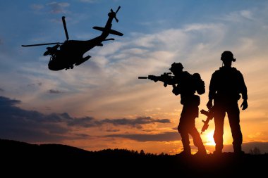 Gün batımının arka planında asker ve helikopter silueti. Konsept - koruma, vatanseverlik, onur. Türkiye, İsrail, Mısır ve diğer ülkelerin silahlı kuvvetleri.