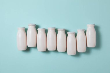 Probiyotik ve prebiyotik süt ürünleri içeren şişeler açık mavi arka planda. Kullanışlı mikroorganizmalı biyo-yoğurt. Biyolojik olarak aktif katkı maddeleri üretimi. Fermantasyon ve diyet sağlıklı yiyecekler.