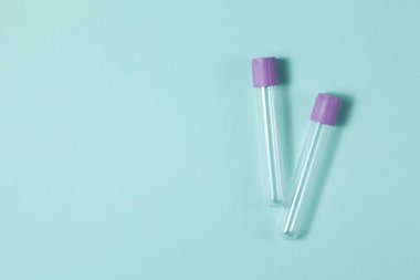 Mor boş vakum kan toplama tüpü testi EDTA ile birlikte turkuaz arka plan üzerinde tıbbi laboratuvar için antikoagülan.