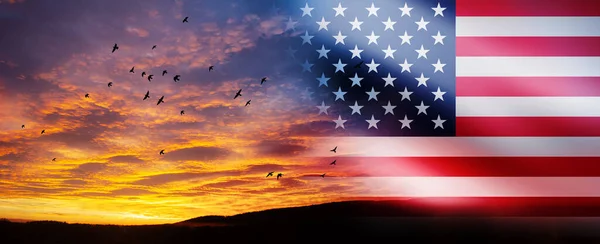 United States of America flag on bright sky at sunset or sunrise with flying birds background. USA Independence day, 4 July. Memorial day. Veterans day.