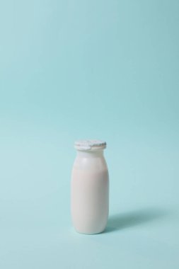 Açık mavi arka planda probiyotik ve prebiyotik süt içeceği şişesi. Kullanışlı mikroorganizmalı biyo-yoğurt. Biyolojik olarak aktif katkı maddeleri üretimi. Fermantasyon ve diyet sağlıklı yiyecekler.