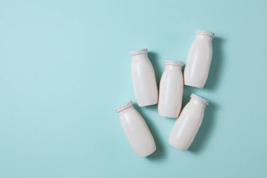 Probiyotik ve prebiyotik süt ürünleri içeren şişeler açık mavi arka planda. Kullanışlı mikroorganizmalı biyo-yoğurt. Biyolojik olarak aktif katkı maddeleri üretimi. Fermantasyon ve diyet sağlıklı yiyecekler.