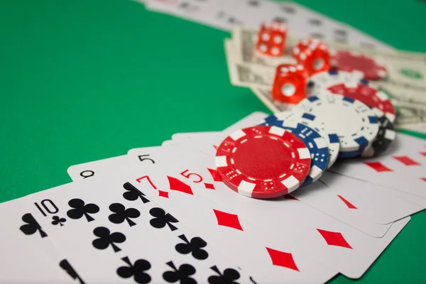 Klassische Spielkarten, Chips, rote Würfel und Dollar auf grünem Hintergrund. Glücksspiel und Casino-Konzept. — Stockfoto