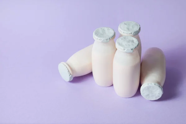 Probiyotik ve prebiyotik içeren şişeler açık mor arka planda süt içecekler.. — Stok fotoğraf