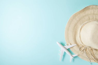 Uçakla yolculuk. Mavi arka planda bir düzen. 2021 yazında tatil ve arka planda güneş şapkası ve uçakla seyahat. Düz yatıyordu.