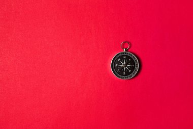 Kırmızı arka planda pusula. Kavram işaretleri. Seyahat, turizm, bilim, kaybol, iş ve tasarım ve dekorasyon aracı. Düz dizayn.